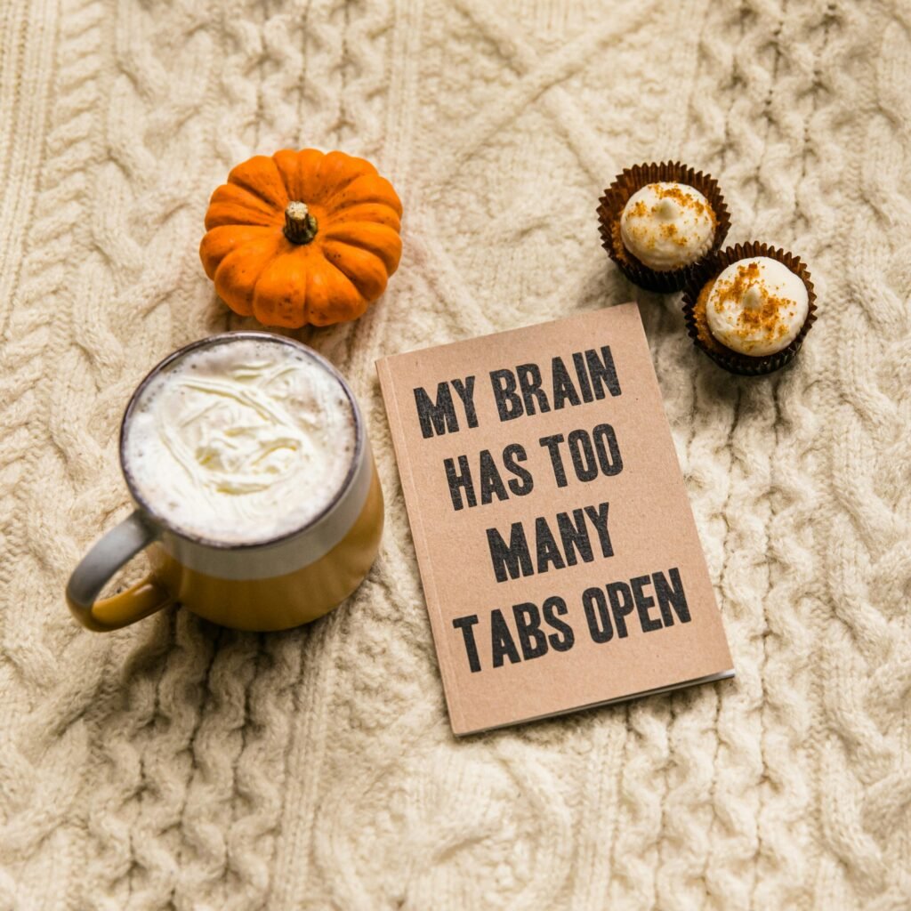 Notebook reading My Brain Has Too Many Tabs Open beside a latte and a mini pumpkin