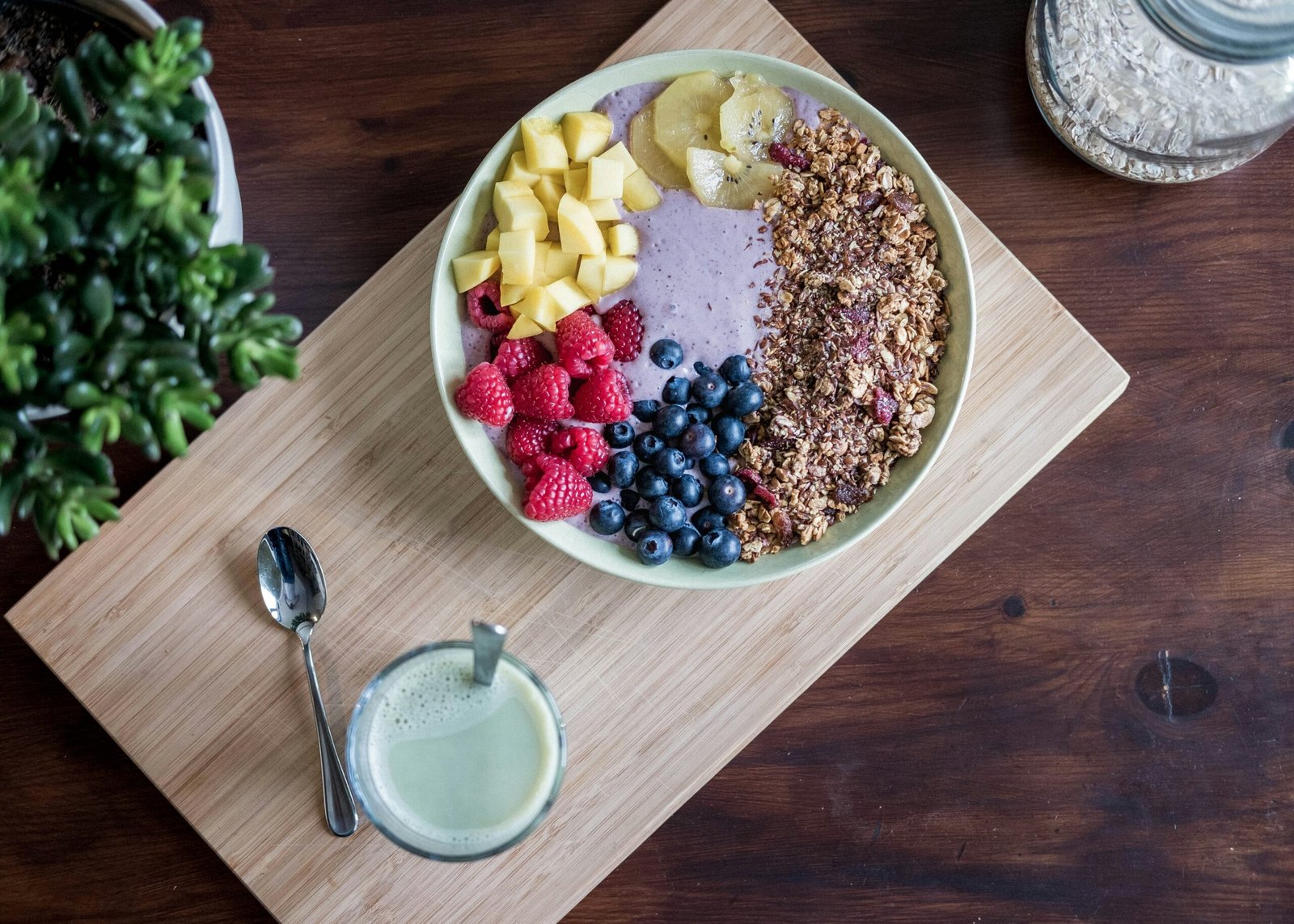 Smoothie bowl topped with mango, raspberries, blueberries and granola for an easy ADHD-friendly breakfast