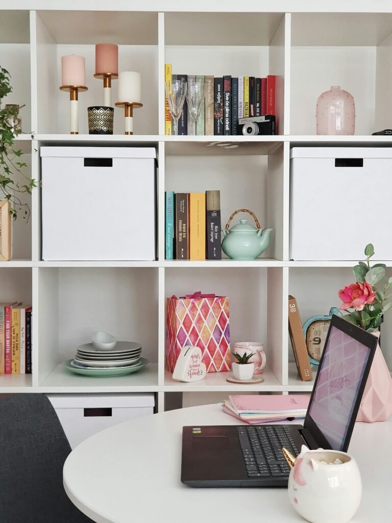 Neatly organized white cube shelving with labeled storage boxes, books and decor