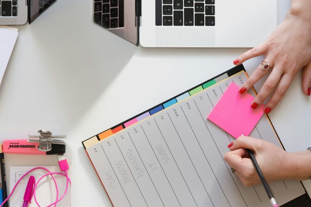 Hands working on a color-coded weekly planner with sticky notes, ideal for weekly planning