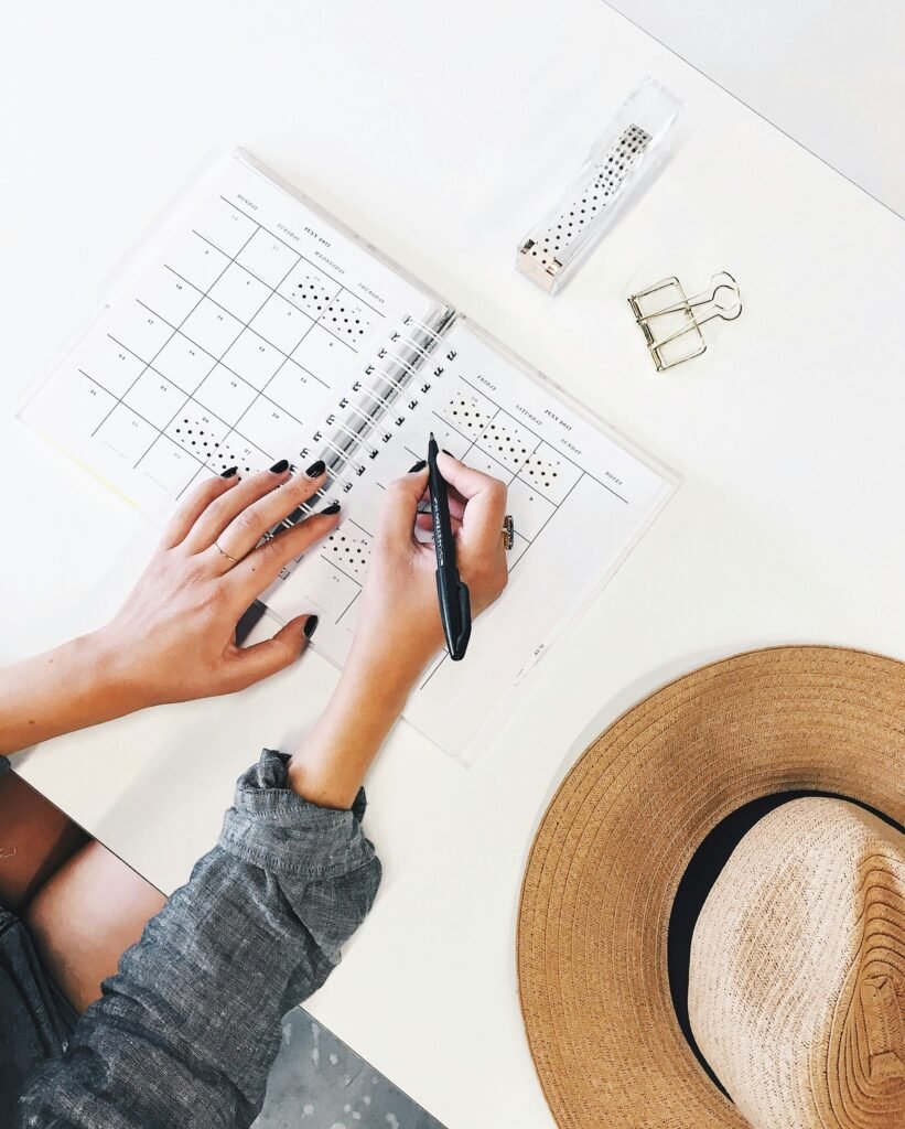 Hands writing on a calendar with a hat